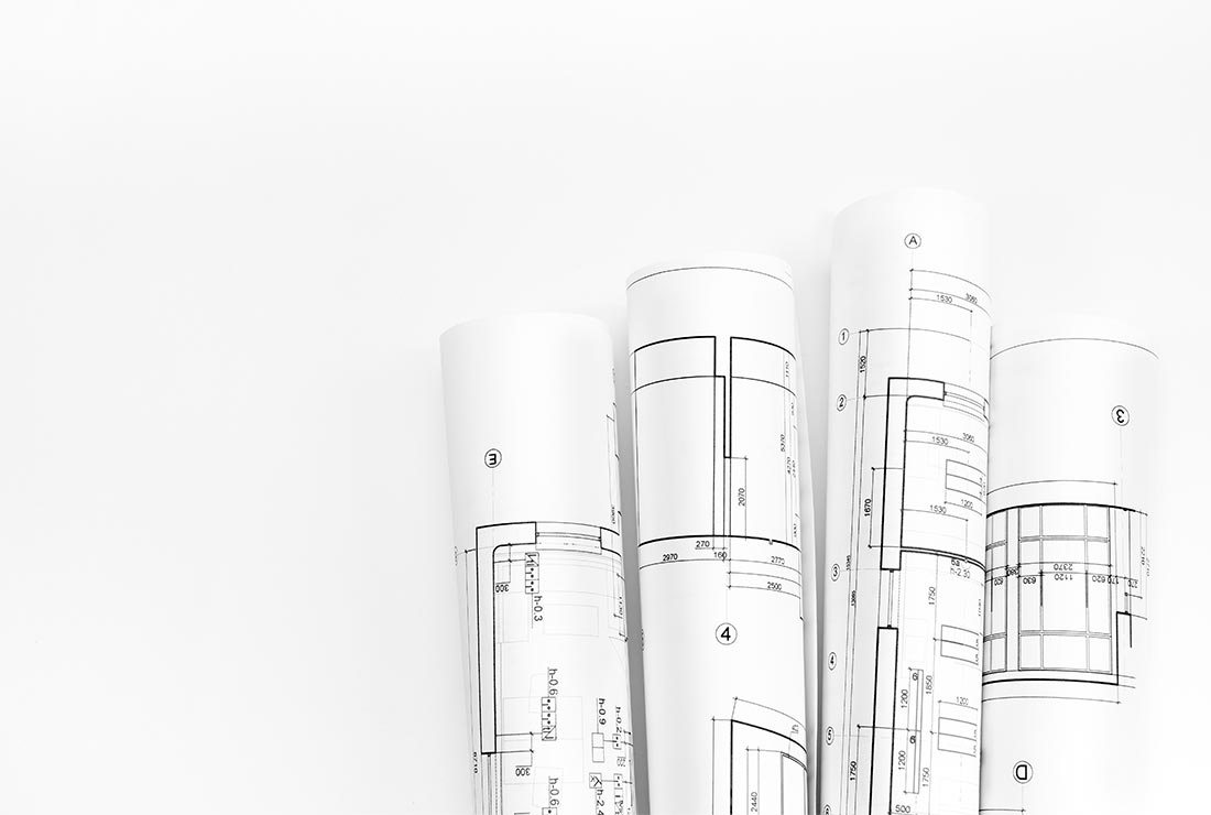 Rolled architectural blueprints showcasing detailed construction plans for a project related to Bear Essentials Handyman Services.