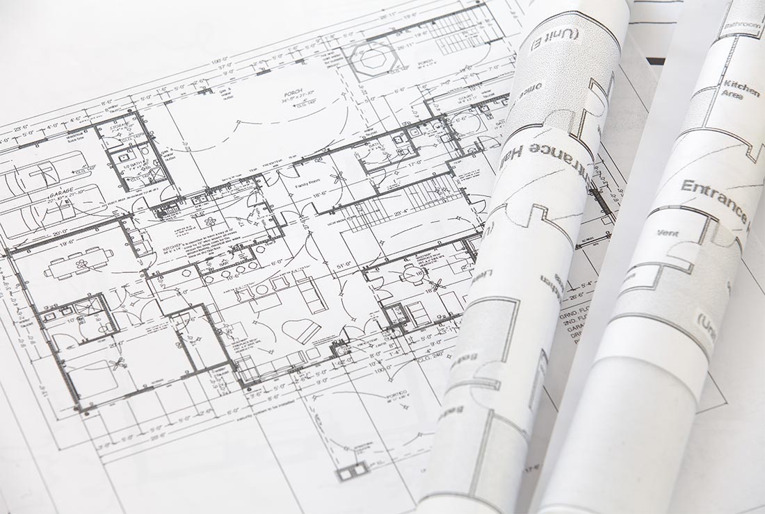 Blueprint of a house design with detailed floor plan and rolled architectural drawings, relevant to handyman services and construction projects in Bear Lake.